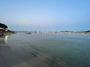 Enjoy a serene beach experience with access to a marina and public space for leisure.