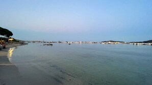A beach with clear water, a pier, and a few boats. - Ruscana by Pinarello Villa Services (Pinarello)