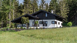 A modern house with a large deck, surrounded by a forest. - Apartment “Chalet Marianna” with Mountain View, Shared Terrace and Wi-Fi (Mölten)