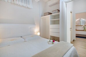 A bedroom with a bed, bedside tables, a wardrobe, and a bathroom with a mirror.