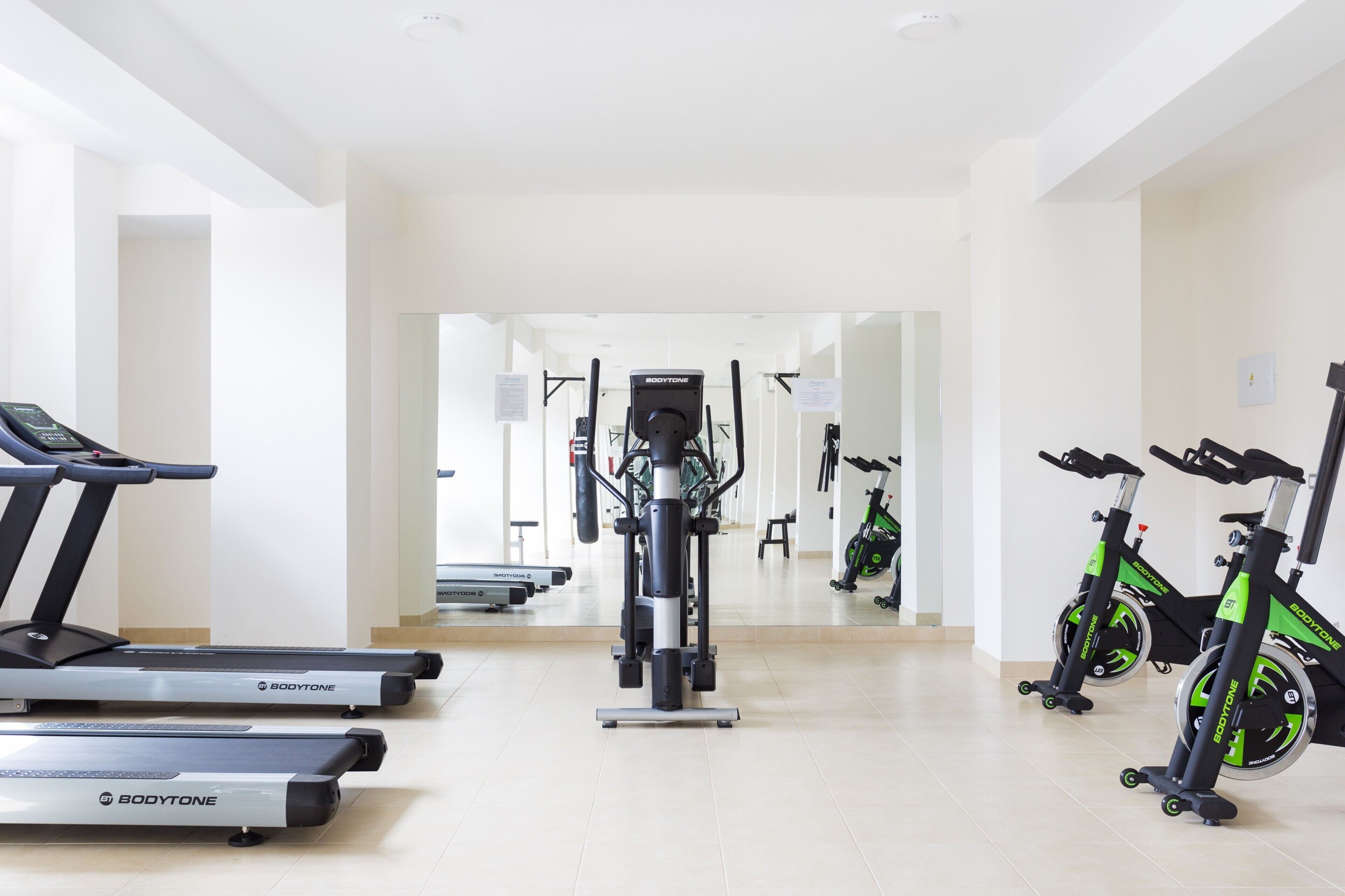A gym with treadmills, a stationary bike, and a rowing machine.