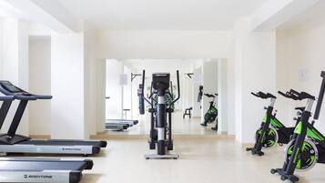 A gym with treadmills, a stationary bike, and a rowing machine.
