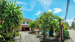A house with a swimming pool, surrounded by lush greenery and a paved driveway. - Private Residence Hosted by Sasithorn (Pattaya)