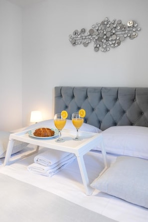 Relax in a serene bedroom with a tufted headboard, bedside table, and modern wall art.