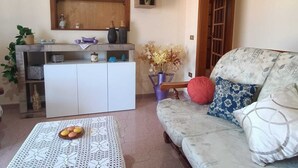 A cozy living room with a sofa, a coffee table, a bookshelf, and a decorative archway. - Casa AuroraRosa (Tropea)