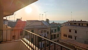 A balcony with a view of the sea and adjacent buildings. - Casa AuroraRosa (Tropea)