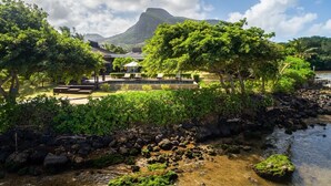 A resort with a pool area, lounge chairs, and a view of a mountain. - Villa Paolita  (Vieux Grand Port)