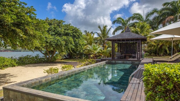 A clear pool with wooden deck, surrounded by lush greenery and a gazebo. - Villa Paolita  (Vieux Grand Port)