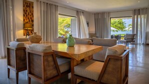 A spacious living area with a wooden table, wicker chairs, and a sofa. - Villa Paolita  (Vieux Grand Port)