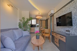 Deluxe kamer, uitzicht op zwembad | Woonruimte | Een 42-inch lcd-televisie met kabelzenders en een televisie