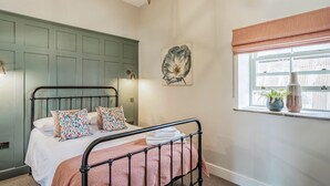 Ein Schlafzimmer mit einem Bett, einer sternförmigen Deckenleuchte, einem Fenster mit Vorhängen und einem Wandbild einer Blume.