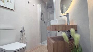 Een bad/douchecombinatie, een bidet, handdoeken