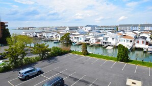 Un port esportiu amb vaixells, un pàrquing i edificis davant del mar.