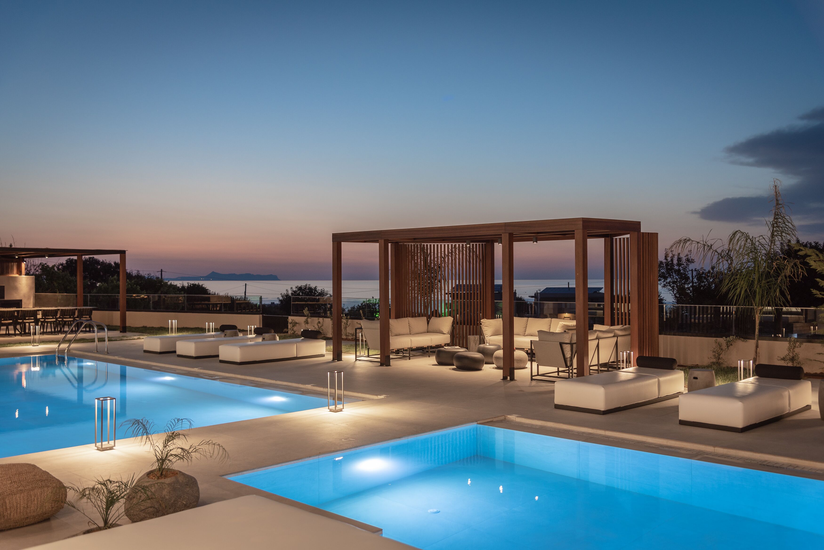A rooftop pool area with lounge seating and a pergola structure.