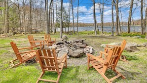 A lakeside setting with wooden Adirondack chairs arranged around a fire pit. - Pocono Lake Home w/ Fire Pit: Walk to Ski Hill! (Pocono Lake)