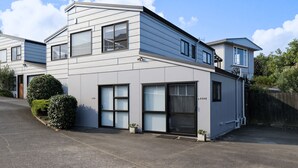 Uma casa moderna de dois andares com garagem, janelas amplas e um jardim bem cuidado.