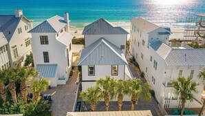 A coastal residential area with white buildings, a beach, and palm trees. - Wilder Dreams - Gulf Front, Pool, Gated Community, Steps to Rosemary Beach (Seacrest)