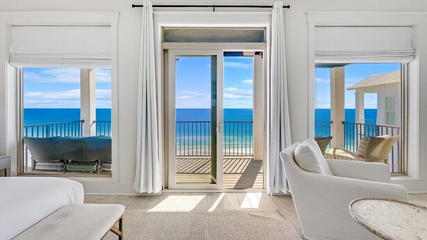A balcony with a view of the ocean, a white sofa, and a bed with a view. - Wilder Dreams - Gulf Front, Pool, Gated Community, Steps to Rosemary Beach (Seacrest)