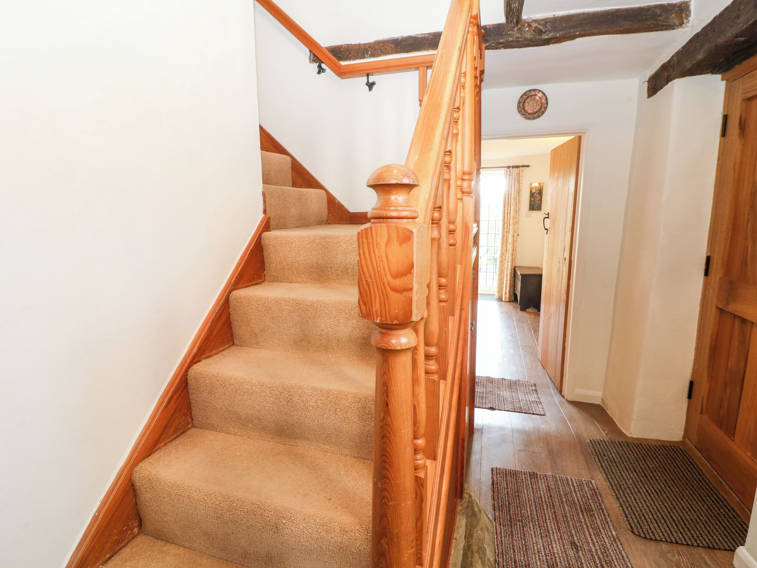 A wooden staircase with carpeted steps leading to a landing.