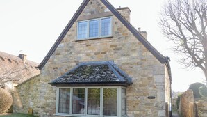 A stone house with a gabled roof and a small porch.
