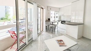 A modern apartment with a balcony, a dining area, and a kitchen. - Cannes: Pointe croisette 1 bdr apartment 100 m to beaches - cute balcony (Cannes)