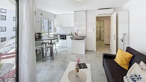 A modern apartment with a kitchen, dining area, and living room. - Cannes: Pointe croisette 1 bdr apartment 100 m to beaches - cute balcony (Cannes)