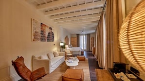Une chambre d’hôtel moderne, équipée d’un canapé, d’un fauteuil, d’une table basse et d’un coin repas agrémenté d’un plateau.