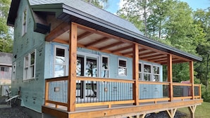 Ein Haus mit überdachter Veranda und einer Terrasse.