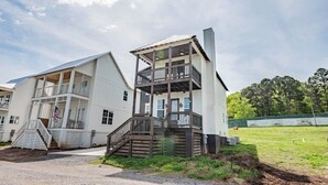 A two-story building with a balcony, a flag, and a staircase.