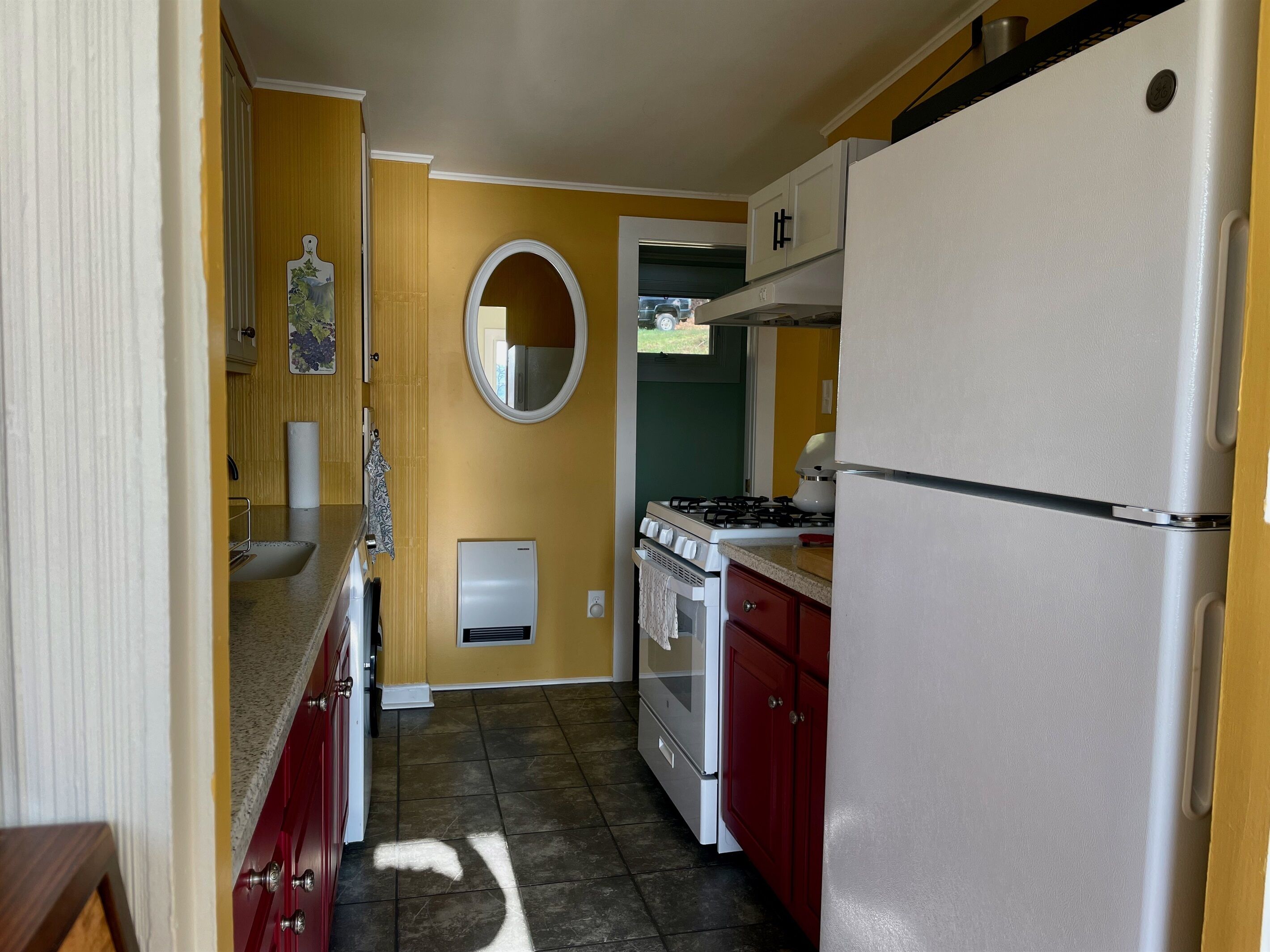 A compact kitchen with a stove, oven, and refrigerator.