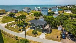 Zona residencial costera con casas, un muelle y una carretera.