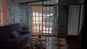 Un saló amb un sofà, una taula rodona petita i vista a través d'una finestra gran.