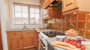 A kitchen with wooden cabinets, a granite countertop, and a tiled backsplash. - 17 Costa Way (Pickering)