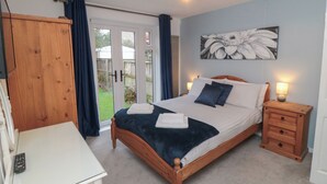A bedroom with a bed, bedside table, wardrobe, and a view of the outdoors. - 17 Costa Way (Pickering)