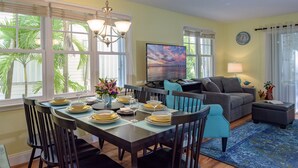 A dining area with a table set for six, a sofa, and a TV in the background. - A Key West State Of Mind at The Key West Golf Club (Key West)