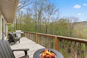 Une terrasse dotée d’un foyer extérieur, de coins salon et d’un barbecue.
