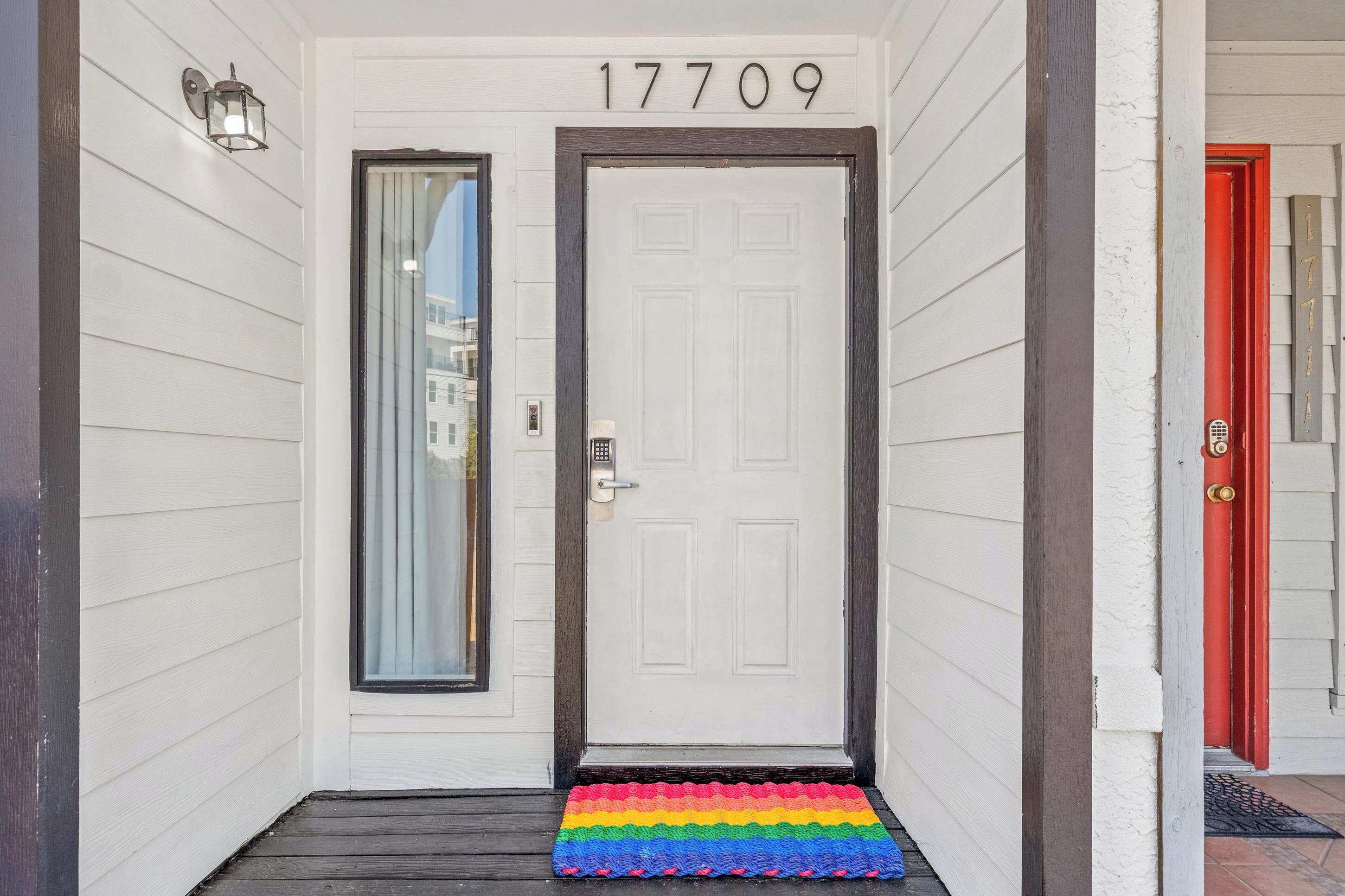 A white door with the number 17709, a black-framed door, and a colorful mat at the entrance.