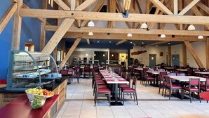 A spacious dining area with high wooden beams, long tables, and red chairs. - La Bessannaise (Bessans)