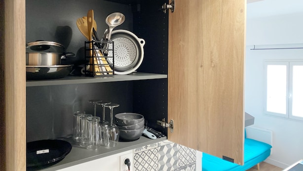 Una cocina con armarios de madera, una encimera y un banco azul.