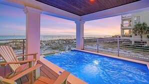 An indoor swimming pool with a view of the beach and ocean at sunset. - Gulf-Front with Rooftop Deck, Theater and Pool (Miramar Beach)