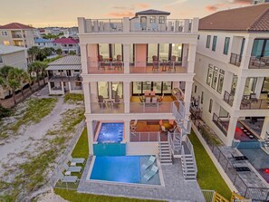 A multi-story residential building with a rooftop pool, outdoor seating, and a view of neighboring houses. - Gulf-Front with Rooftop Deck, Theater and Pool (Miramar Beach)