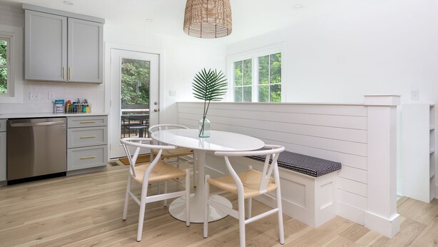 A modern kitchen with white cabinetry, a round dining table, and a bench. - Cottontail Cottage | Pet-friendly, Fire Pit & 10 Min. to Downtown AVL! (Asheville)