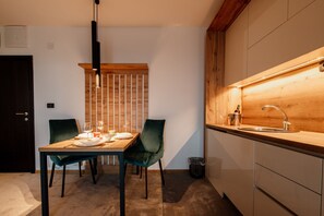 Køleskab, køkkentøj/tallerkener/redskaber, spisebord