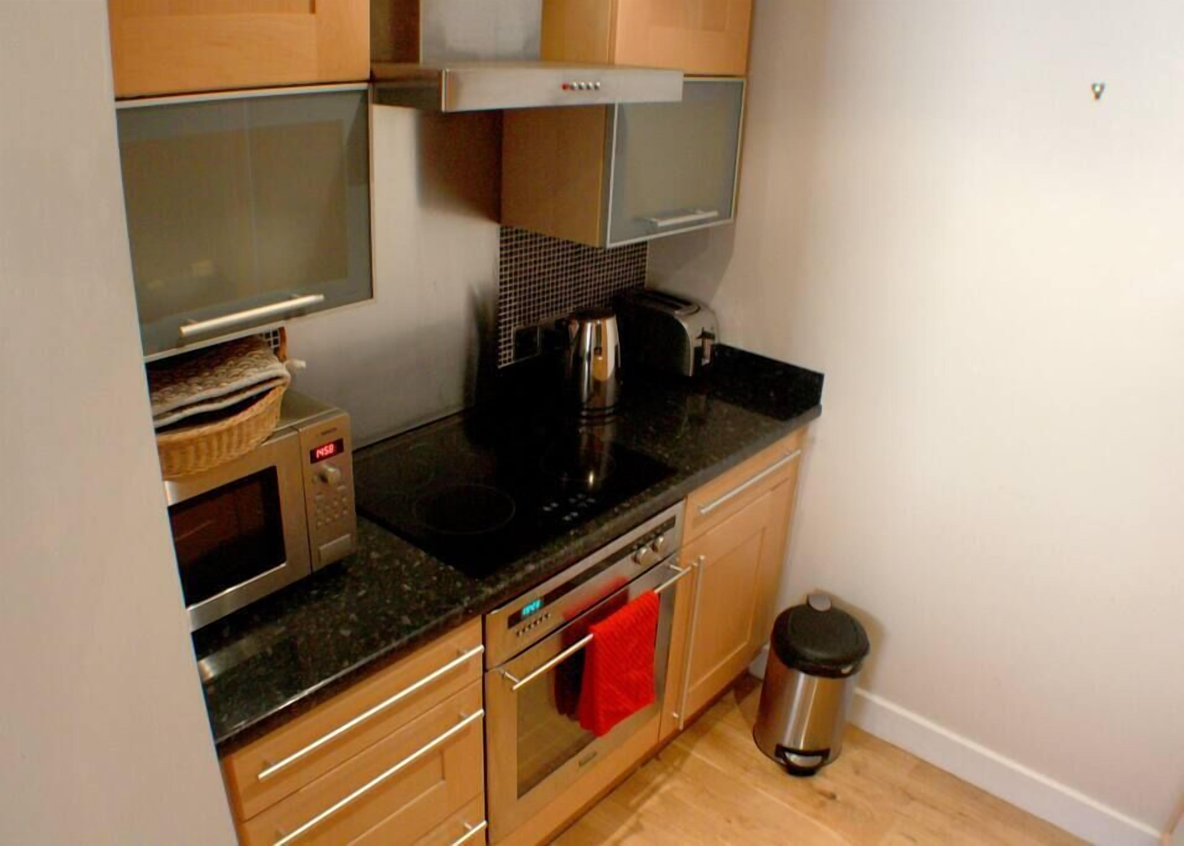 Una cucina compatta con forno a microonde, forno e macchina da caffè.