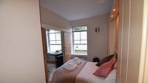 Ein Schlafzimmer mit einem Bett, einem Fenster und einem Schreibtisch.