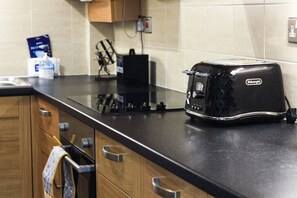 Een koelkast, een vaatwasser, kookgerei, borden en bestek