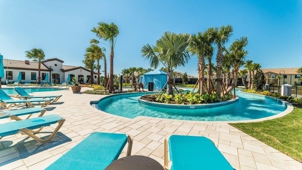 Relax by the resort pool surrounded by palm trees and lounge chairs.