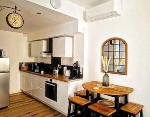 Enjoy meals at the round dining table in front of a large arched window.