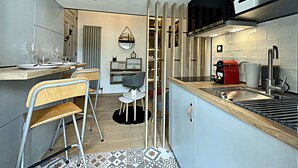 Una cocina compacta con comedor, estufa integrada y un pequeño rincón de estar.