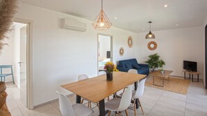 A modern living room with a dining area, a sofa, a TV, and decorative mirrors. - apart Levante shared swimming pool, bbq (Calenzana)